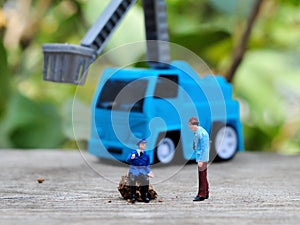 Miniature People and toys: Worker at the construction with chery picker truck background