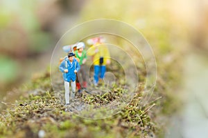 Miniature people : traveler walking on the roads are cluttered with grass. Used to travel to destinations