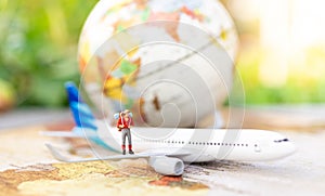 Miniature people: travelers with backpack standing on world map travel by plane. Image use for travel business concept