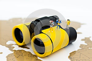 Miniature people: Travelers standing on a world map with binoculars. Image use for travel , business concept