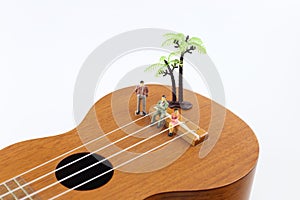 Miniature people on ukelele isolate