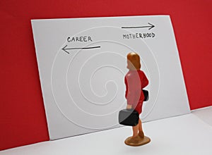 Miniature people, woman decides between a career and a child. Bilogical clock, feministmambitions, job or family dilemma photo