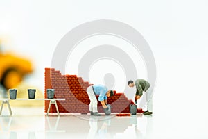 Miniature people: Worker fix the wall before the world. Concepts of finding a solution, problem solving and challenge