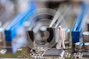 Miniature People: Worker professional checking technology inside old personal computer.