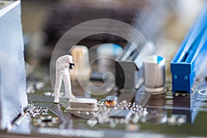 Miniature People: Worker professional checking technology inside old personal computer.