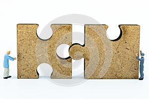 Miniature people : Worker pushing back jigsaw puzzle pieces . Image use for solve, finding solution, business vision concept