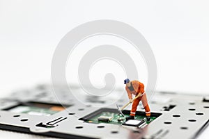 Miniature people: Worker repairing circuit board ,electronics repair. Use image for support and maintenance business