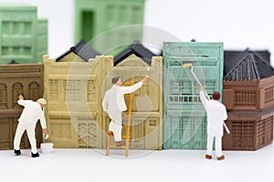 Miniature people: Workers are painting the building in town. Image use for business concept