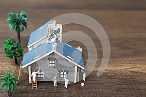 Miniature people: Workers team painting a new home