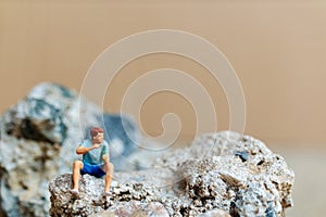 Miniature people , A young man sipping beer and smoking cigarettes