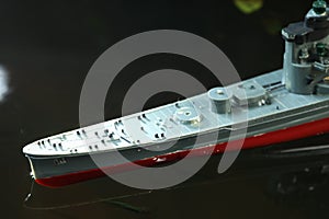 Miniature plastic model ship in the water scene.