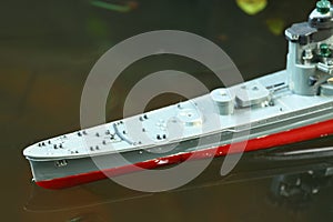 Miniature plastic model ship in the water scene.
