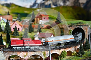 Miniature railway model with model freight train that exit from a tunnel on a mountains ambientation. Toy Train