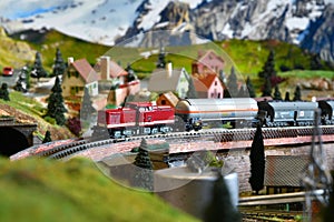 Miniature railway model with model freight train on a mountains ambientation. Toy Train
