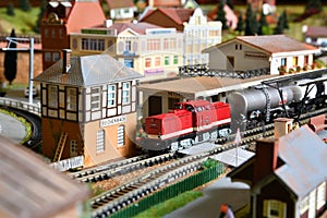 Miniature railway model with trains. Toy Train with wagons at Railway Station in a city