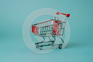 Miniature retail symbol tiny shopping cart on isolated background