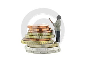 Miniature robber model standing on a pile of Euro coins