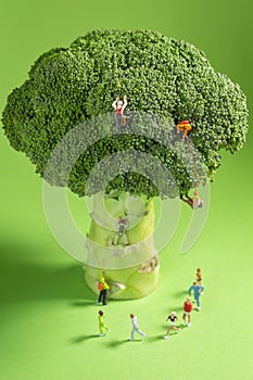 Miniature Runners jogging in a circle around a broccoli to train fitness and endurance for better health