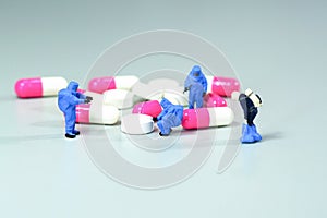 Miniature scientist at work with Medicine pills