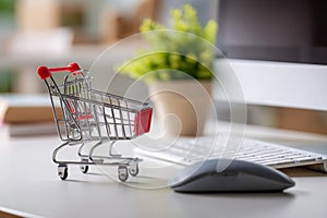 Miniature shopping cart on a desk next to a computer keyboard and mouse representing online shopping and e-commerce concepts in a
