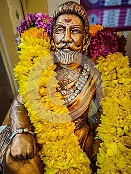 Miniature sitting Statue of Famous king Shivaji in India with selective focus on the face and background blur