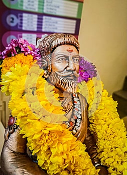 Miniature sitting Statue of Famous king Shivaji in India with selective focus on the face and background blur