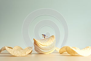 Miniature skier skiing down potatoe chips