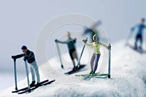 Miniature skiers in a snowy landscape