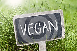 Miniature slate plate in the grass with white lettering vegan