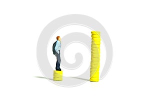 Salary raises and gap concept. A businessman standing above coin money stack