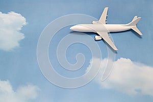 Miniature toy airplane on blue sky with clouds. Trip by airplane.