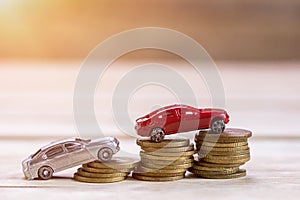 Miniature toy car and coin money on wood table background with s