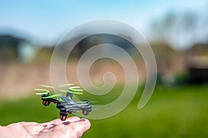 Miniature toy remote controlled drone taking off from a hand