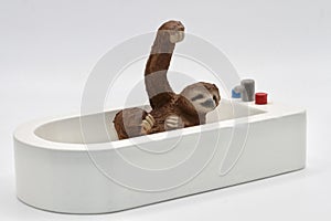 miniature toy of a sloth taking a bath on a bath tub