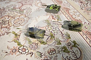 miniature toy soldiers and tank on board. Close up image of toy military at war.