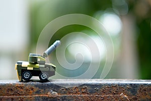 Miniature toys plastic tank on nature background