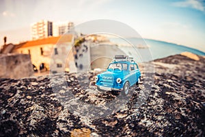 Miniature travelling car with luggage on a roof.