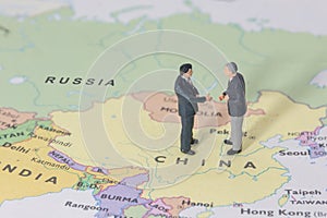 Miniature two businessman shakehand on china map photo