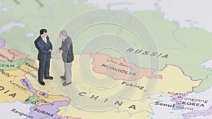 Miniature two businessman shakehand on china map photo