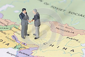 Miniature two businessman shakehand on china map photo