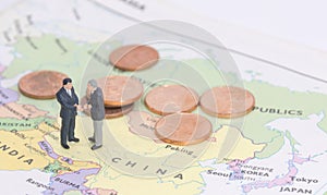 Miniature two businessman shakehand on china map photo