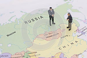 Miniature two businessman shakehand on china and russian map photo