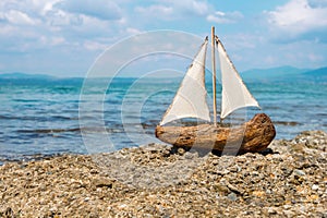 Toy boat in the sea waves. Travel concept. Sailer on beautiful seascape background. Water sports concept. Fascinating photo