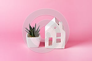 Miniature white toy house and succulent on pink pastel background Trendy Background Property Insurance dream home concept copy