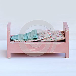 Miniature wooden bed for doll.