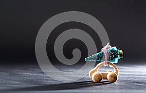 Miniature wooden car carrying a Christmas tree