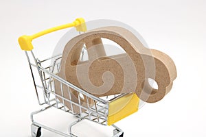 Miniature wooden car and shopping cart on white background. Concept of buying new car.