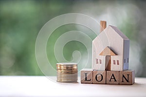Miniature wooden home put on wooden block word with loan