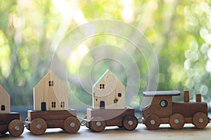 Miniature wooden home on wood toy train. Concept of move home