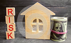 Miniature wooden house, dollars and the inscription ` Risk `. Buying a house, apartment and financial risks. Loss of property for